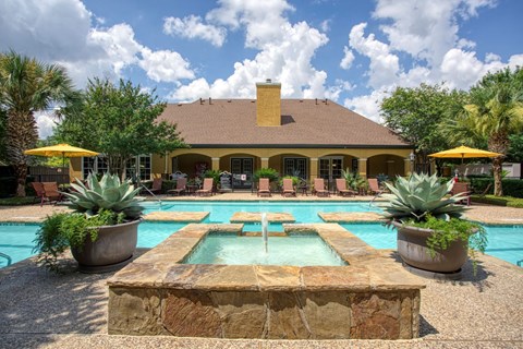 a swimming pool with a fountain in front of a house